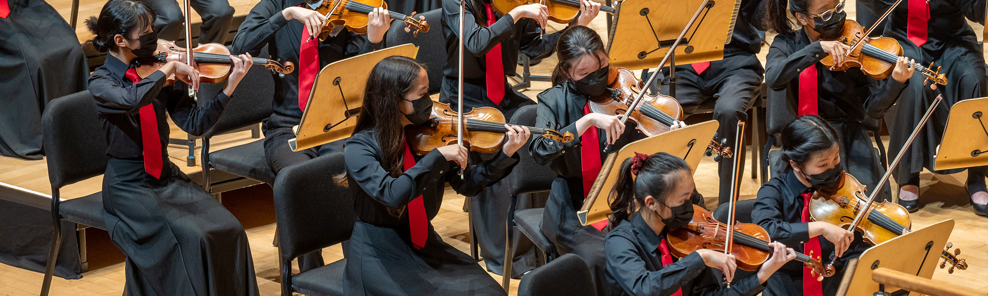 Members of Pacific Symphony Santiago Strings playing on stage