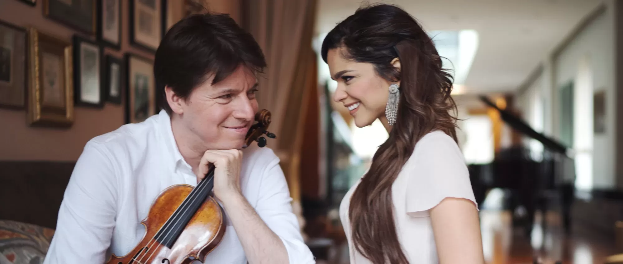 violinist Joshua Bell and vocalist Lariisa Martinez looking at each ot