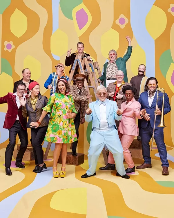 Members of the ensemble Pink Martini in front of a colorful background