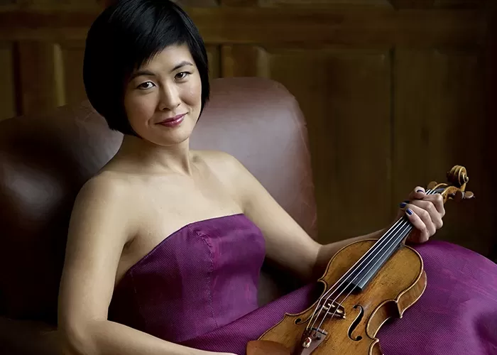 Jennifer Koh in a purple dreess with her violin