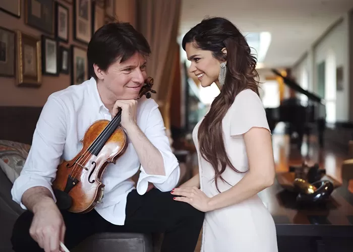 Violinist Joshua Bell looking at vocalist Larisa Martinia