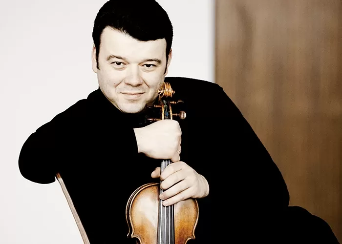 Vadim Gluzman sitting and holding his violin