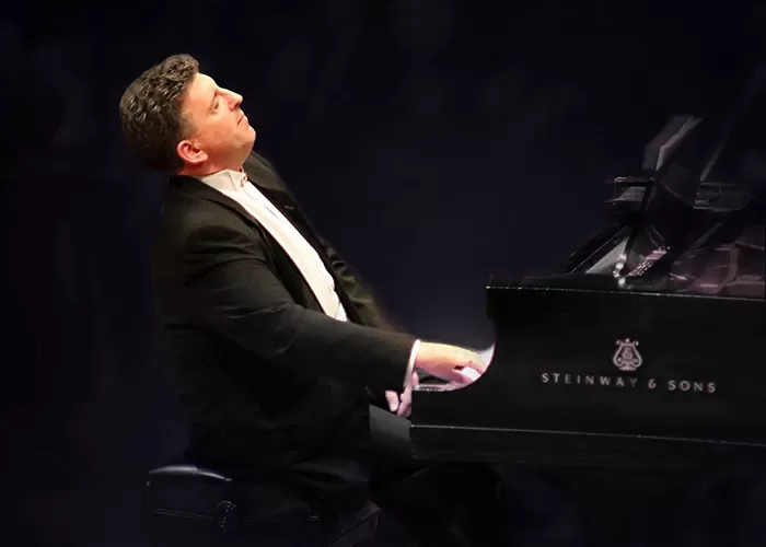 Jeffrey Biegel leading back playing the piano